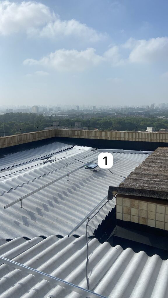 Microinversores Hoymiles HMS-1800 instalados sob os painéis no telhado comercial