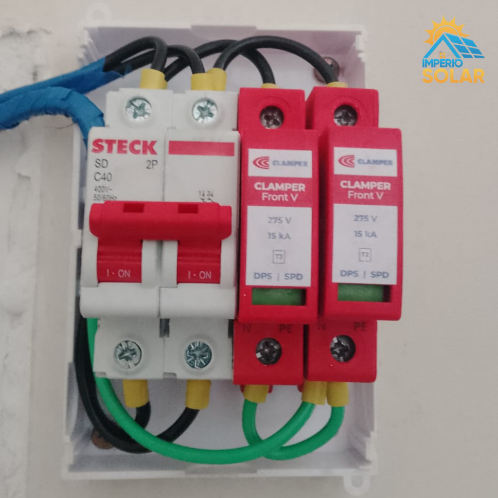 Detalhes da fixação em telhado colonial cerâmico e do quadro de proteção QDC com DPS Classe I e II — padrão técnico para ambientes litorâneos com exposição à maresia.