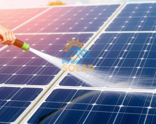 placas solares sendo limpas por uma pessoa com uma mangueira de pressão.